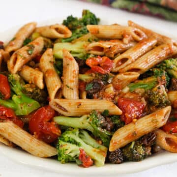 Penne with tomatoes, broccoli, raisins, and walnuts