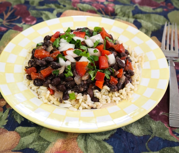 Cuban Inspired Black Beans and Brown Rice served on a yellow plate