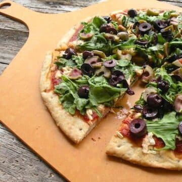 Spinach or arugula and olive pizza