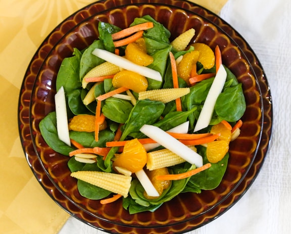 Spinach Baby Corn Salad with oranges being served