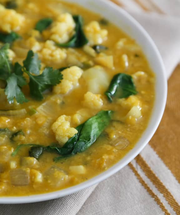 vegan soup with cauliflower and lentils in a white bowl