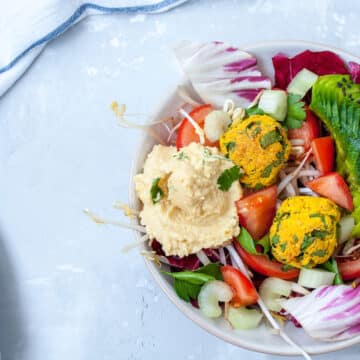 Vegan salad with falafel, hummus, vegetables. View top on gray concrete background. Vegan Food Concept.