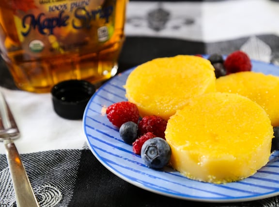 Tube polenta slices with syrup and fruit