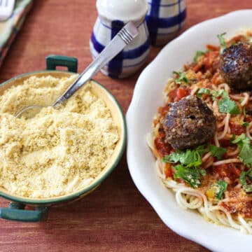 Vegan meatballs on pasta with vegan parmesan cheese