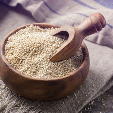 White quinoa seeds on a wooden background