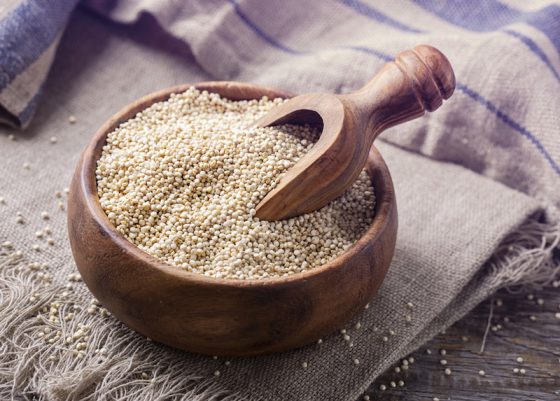 White quinoa seeds on a wooden background