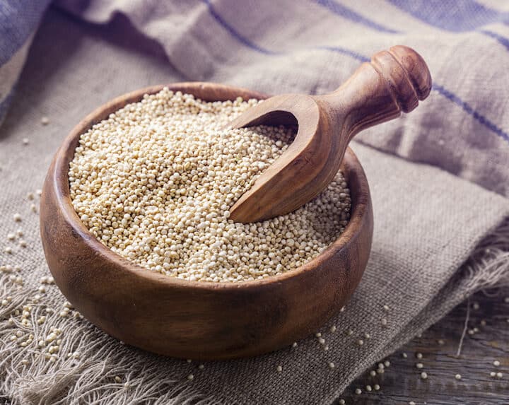 White quinoa seeds on a wooden background