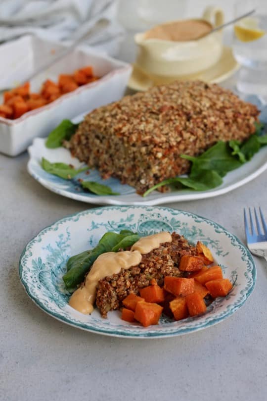 slice of thanksgiving nut roast on plate with roast in background