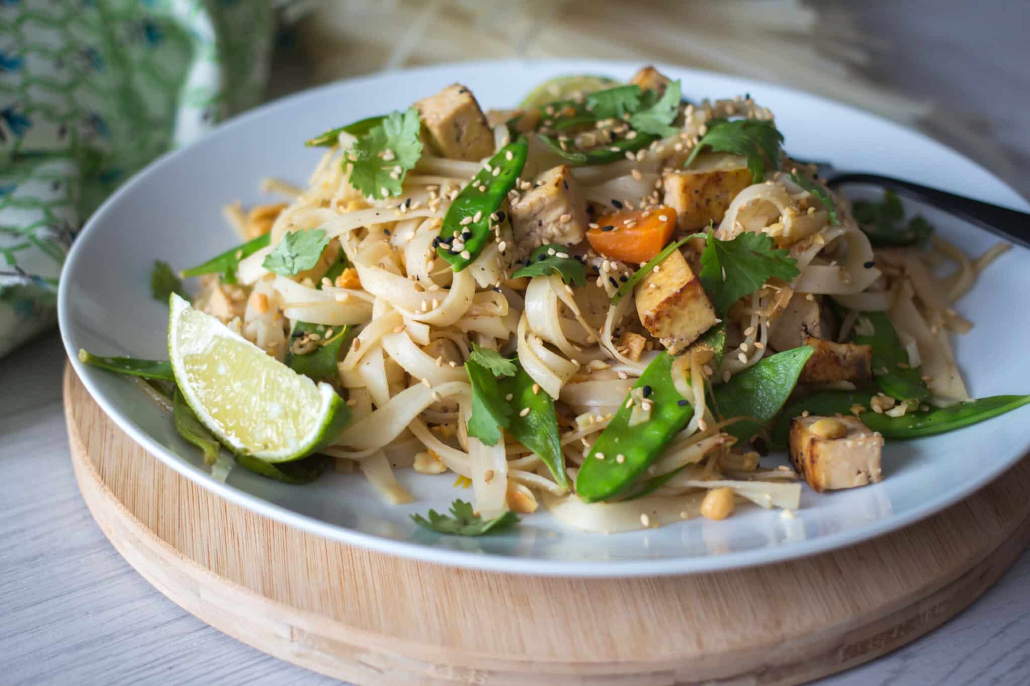 plate of vegan pad Thai on a wooden stand