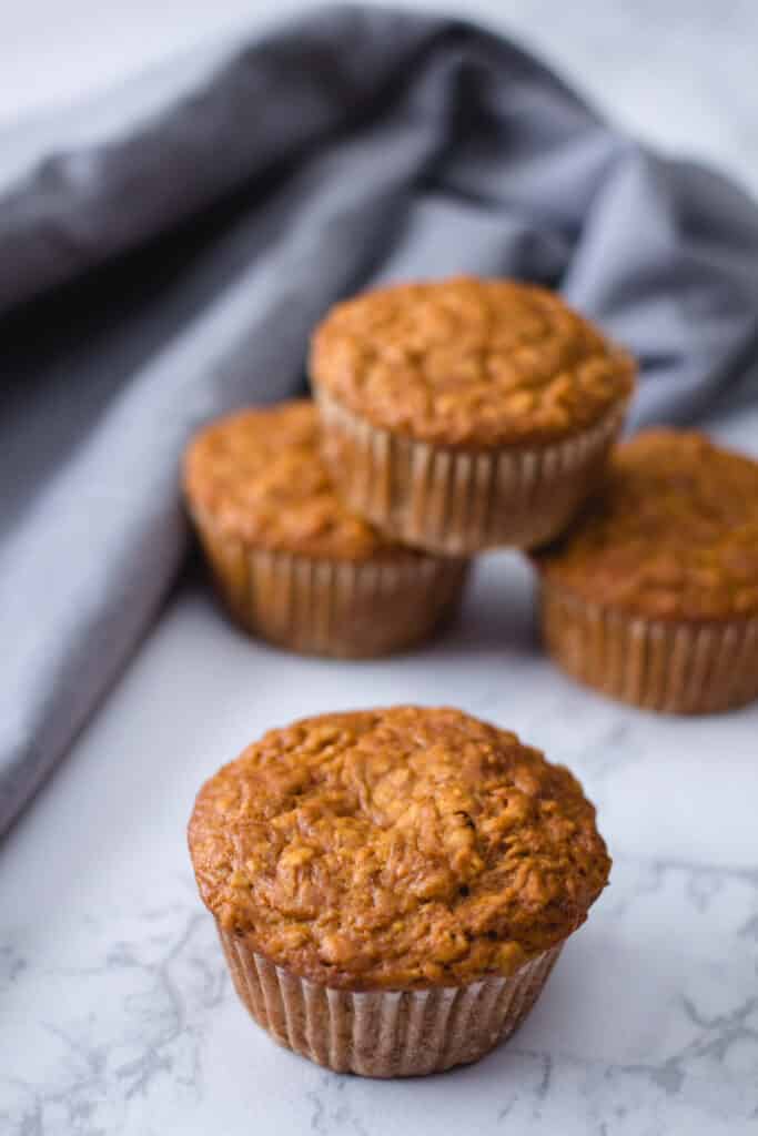 vegan bran muffins stacked on a blue napkin