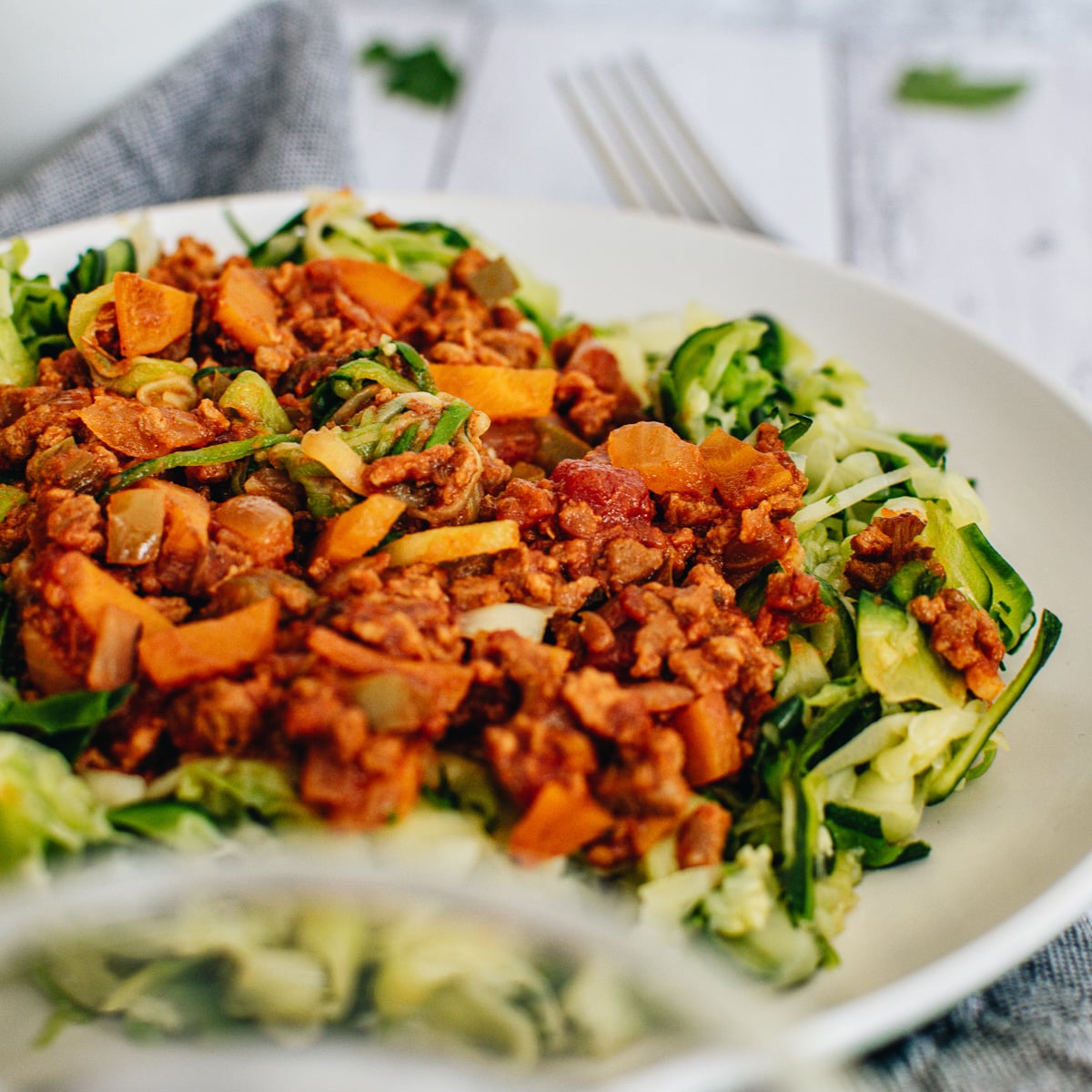 close up vegan zucchini noodles topped with vegan bolognese sauce