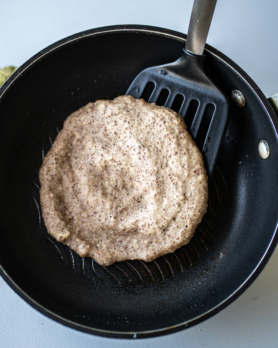 flipping a vegan almond flour pancake in the pan