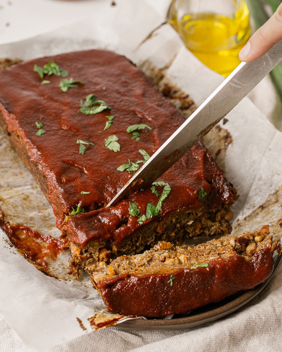 cutting a slice of vegan lentil meatloaf