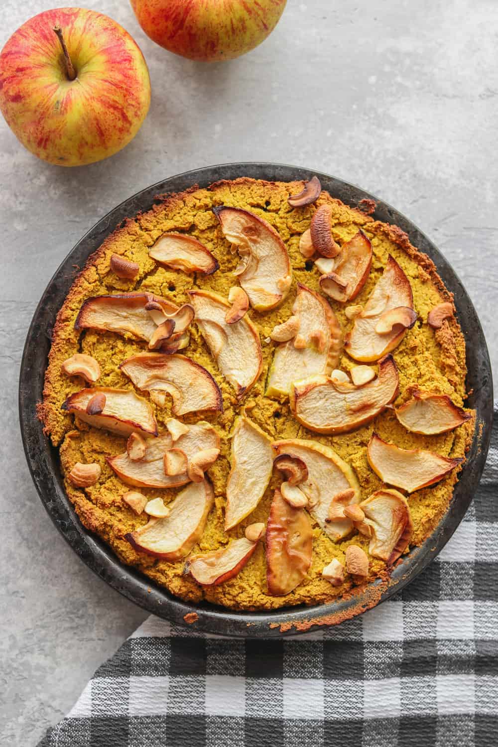 vegan chickpea cake topped with apples in a baking dish