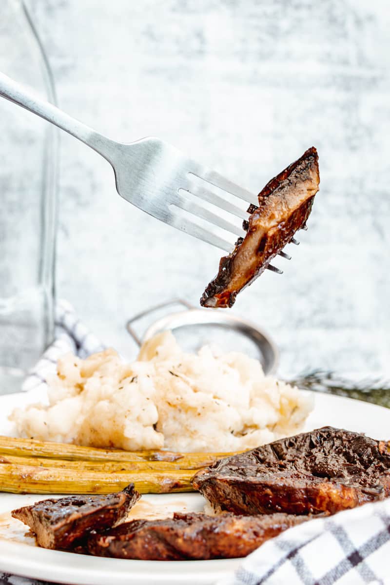 piece of portobello mushroom steak on a fork