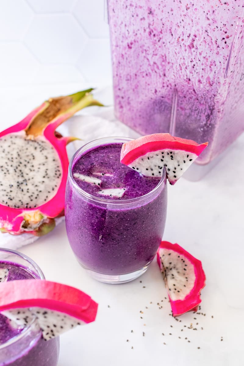 glass of dragon fruit smoothie in front of blender