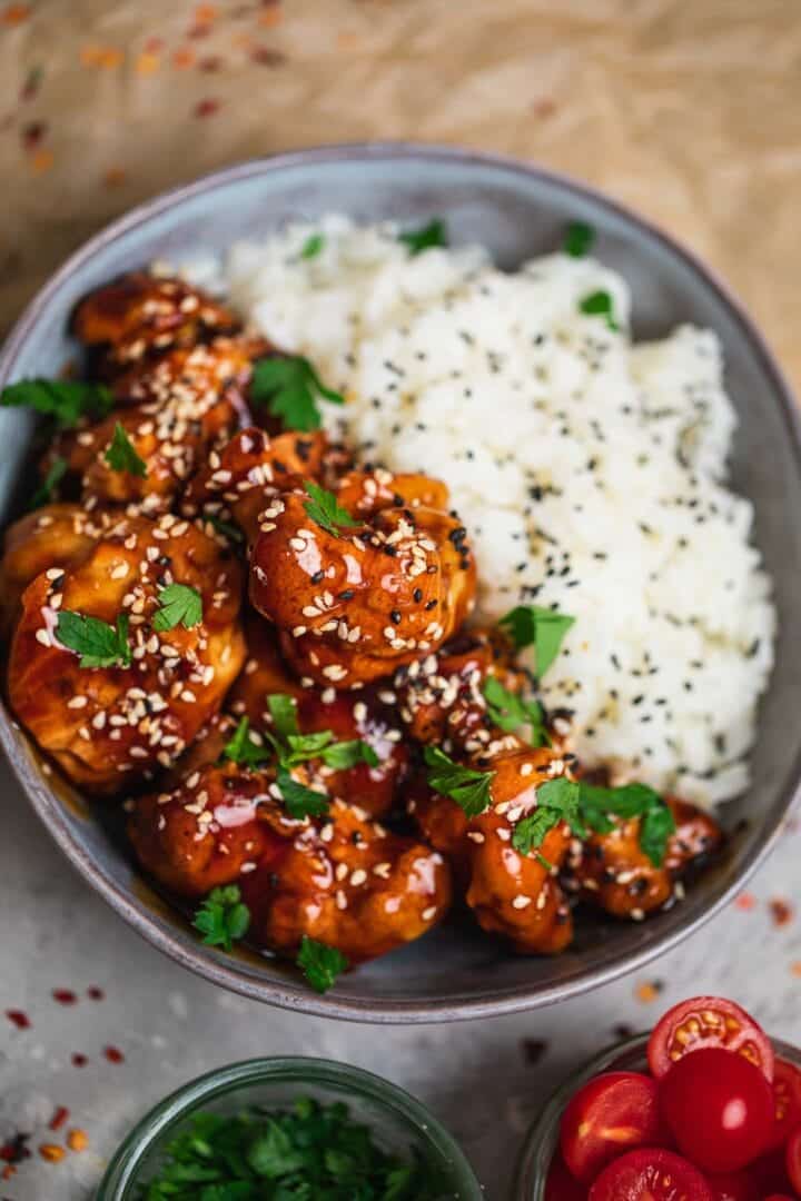 Bowl of crispy cauliflower served with sweet and sour sauce and rice
