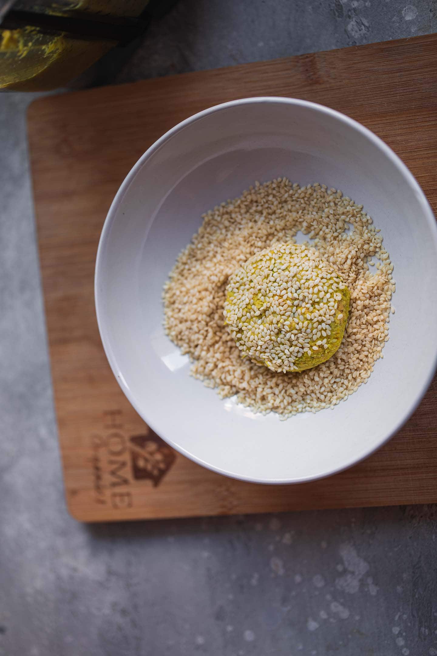 Falafel being coated in sesame seeds