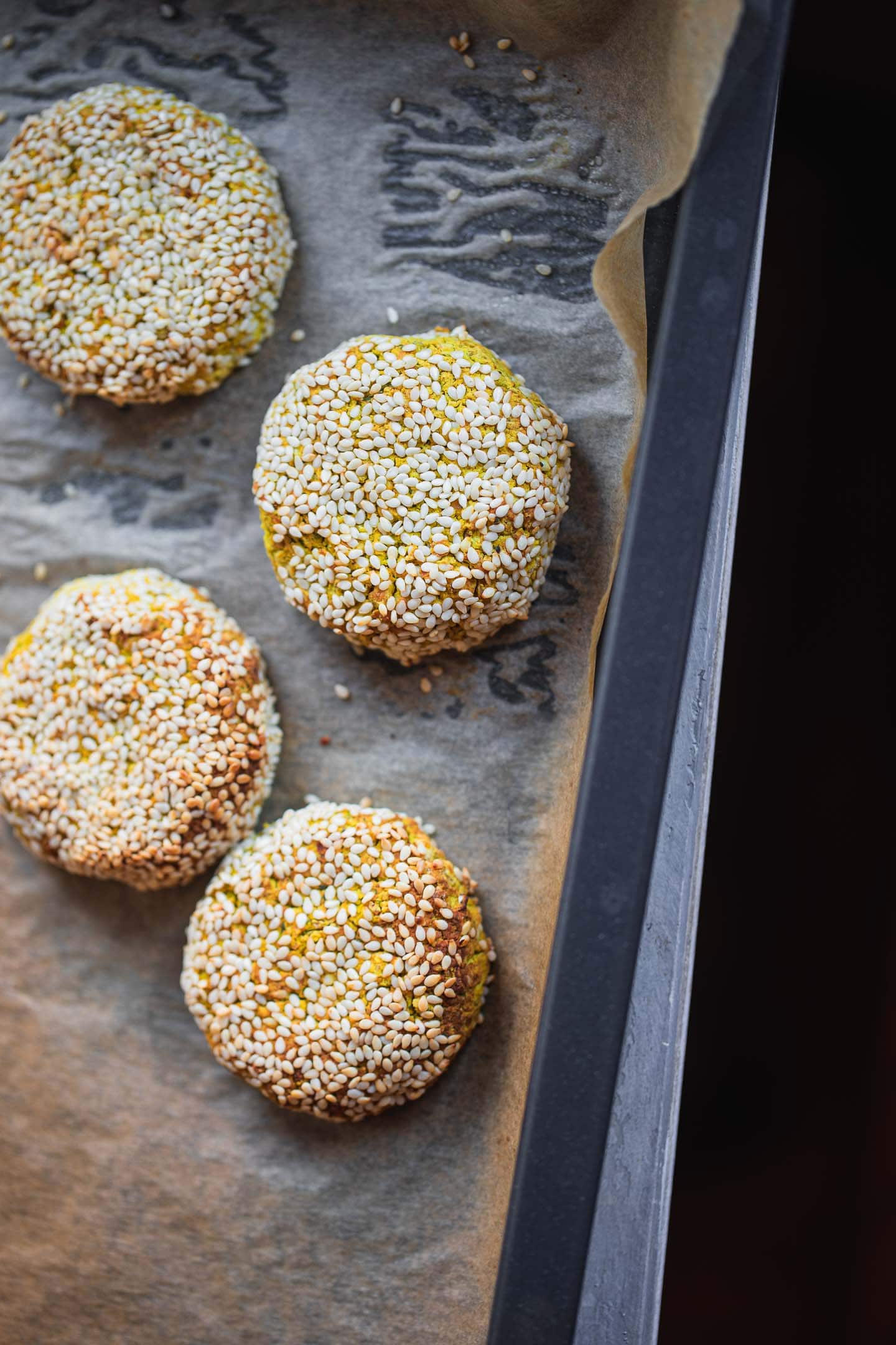 Gluten-free falafel with sesame seeds on a baking tray