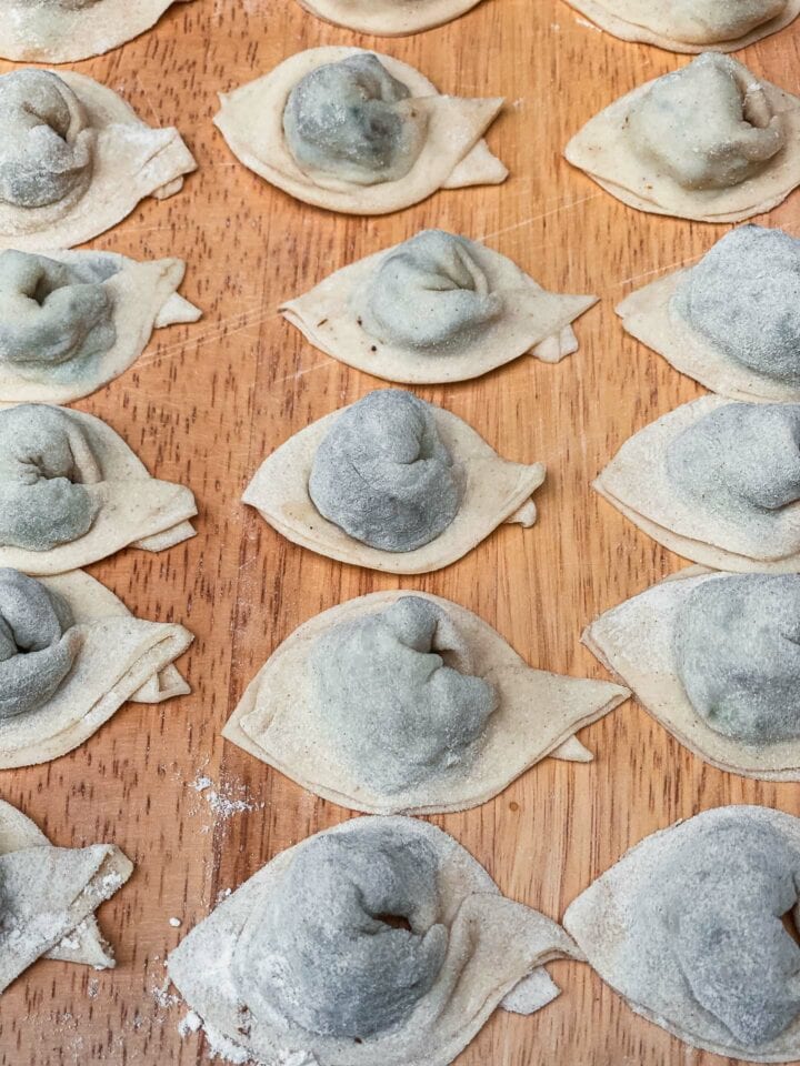 Homemade wontons on a wooden board for vegan wonton soup