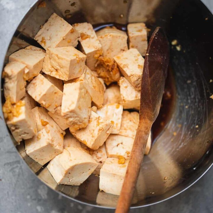 tofu being tossed in marinade