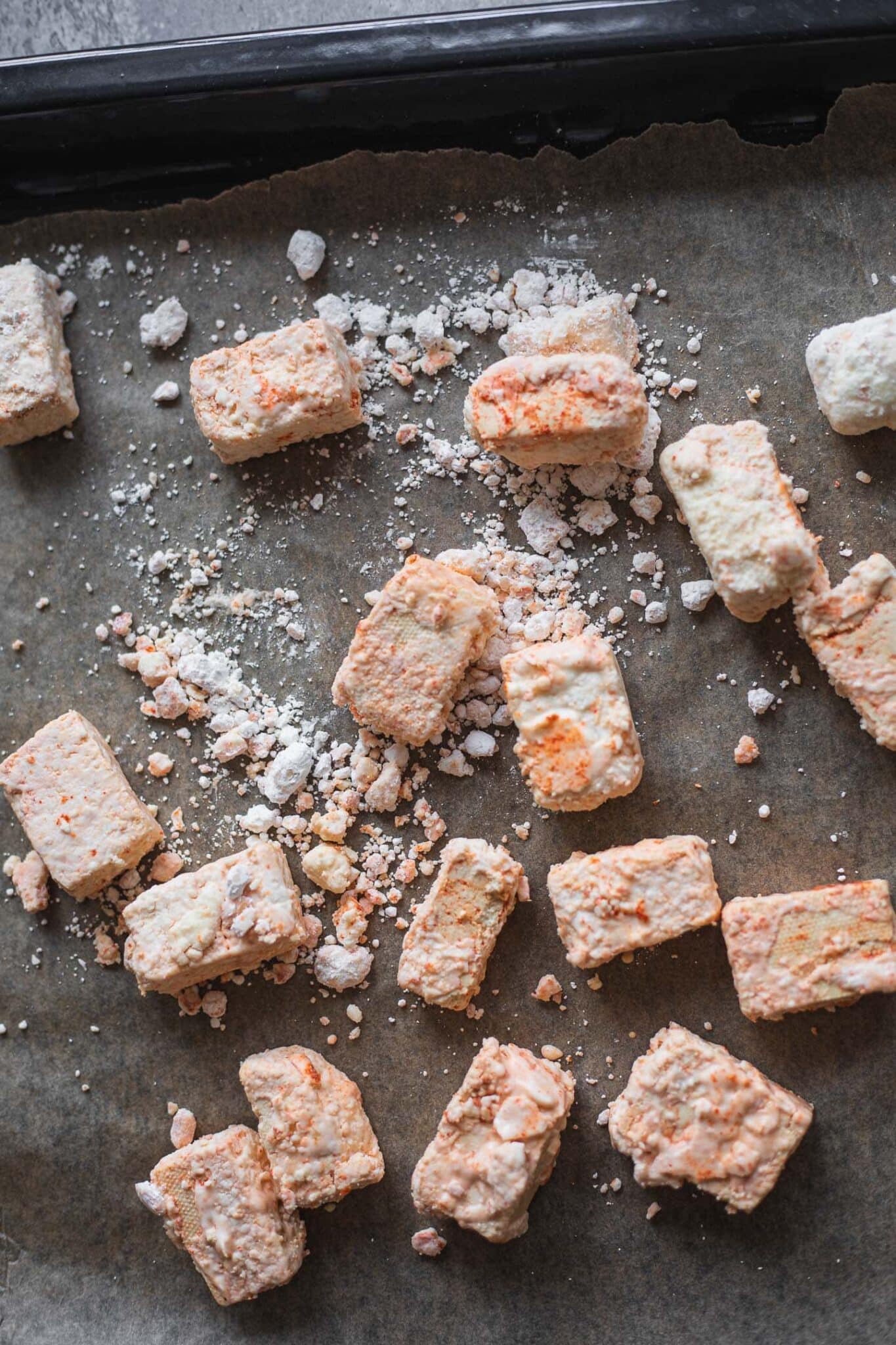 tofu cubes being tossed in cornstarch