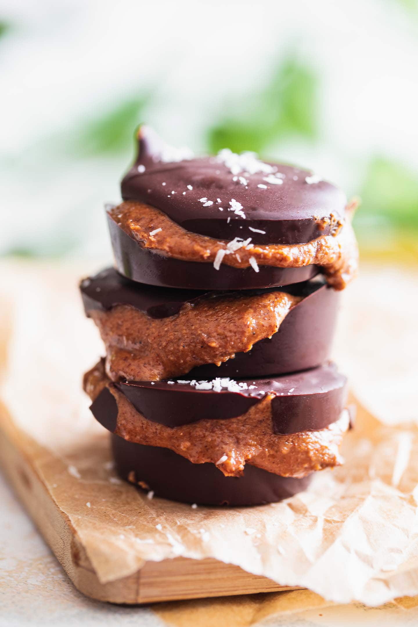 Vegan peanut butter cups standing on a sheet of parchment paper