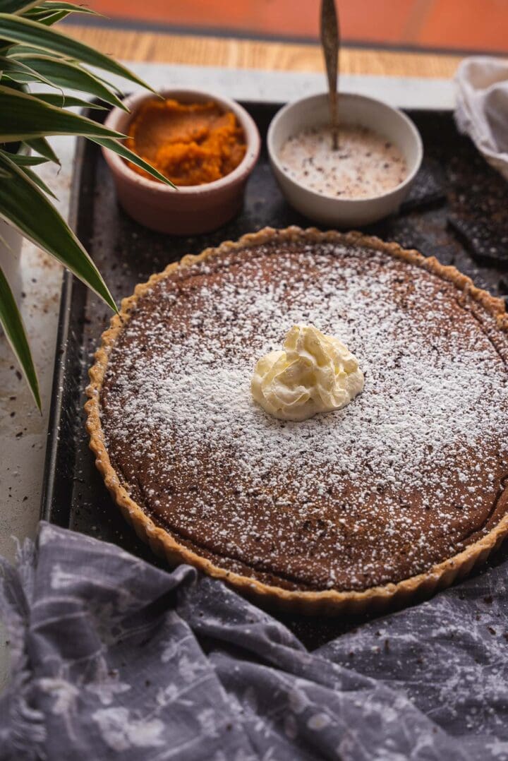 Vegan pumpkin pie topped with whipped cream
