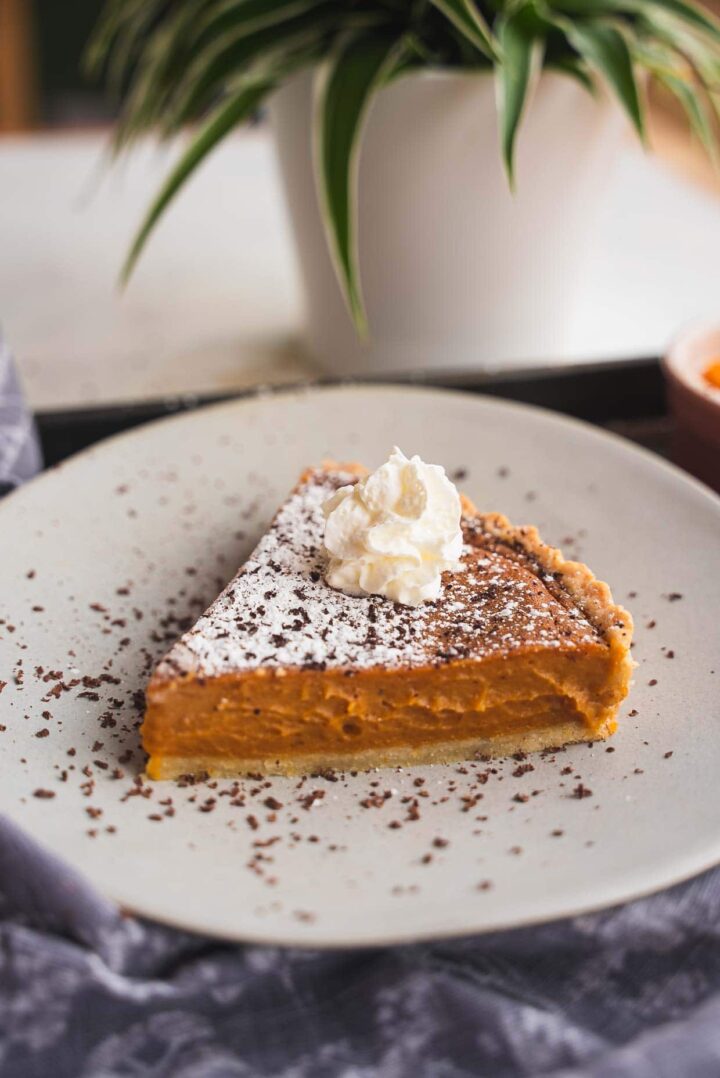 Vegan pumpkin pie being served on a white dish