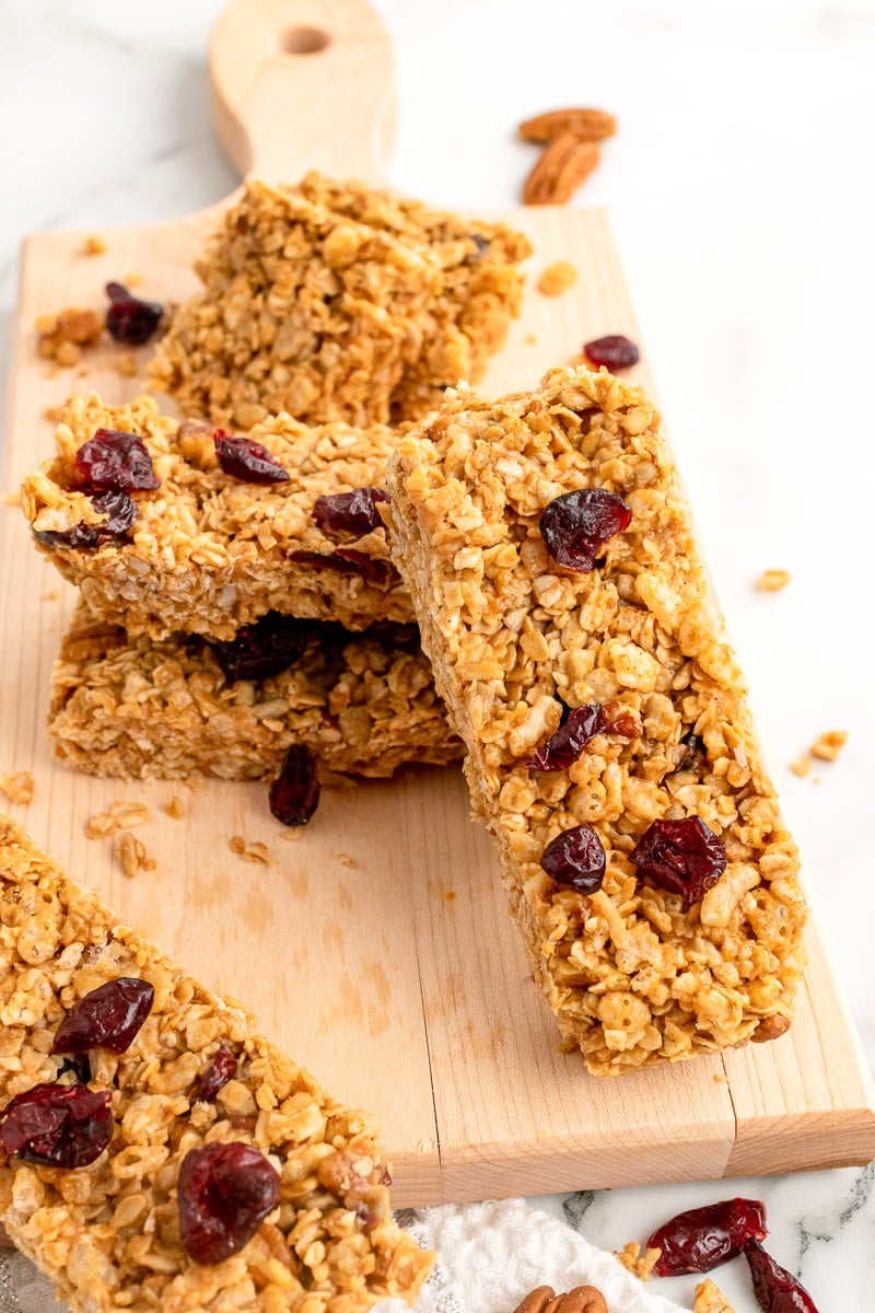 vegan granola bars stacked on wooden cutting board