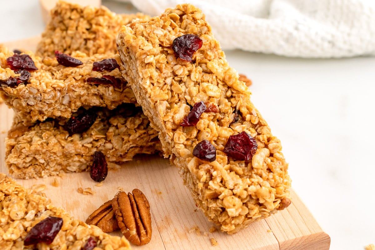 side view of stacked vegan granola bars on wooden cutting board