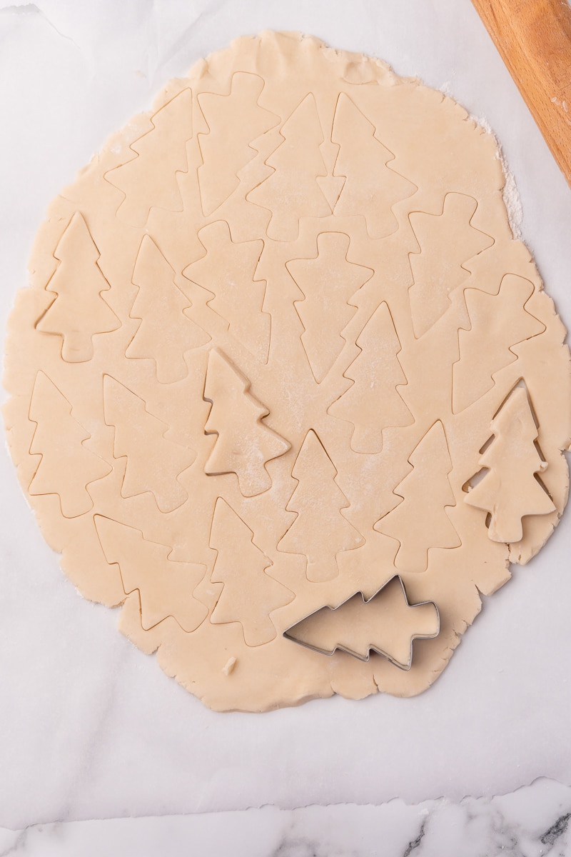 rolling out the dough and cutting out christmas tree shapes