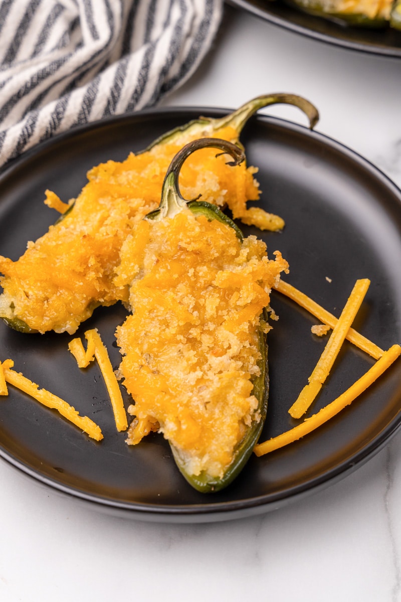 vegan jalapeno poppers being served on a black plate