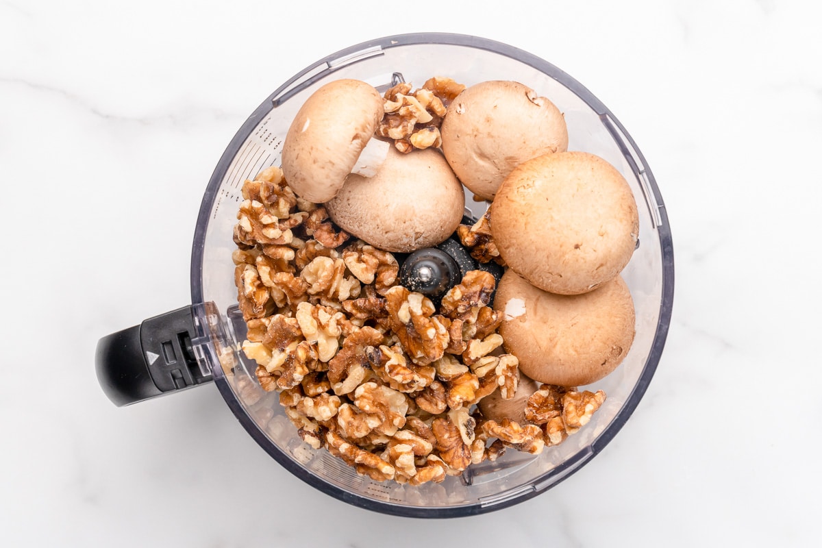 walnuts and mushrooms being processed in the food processor