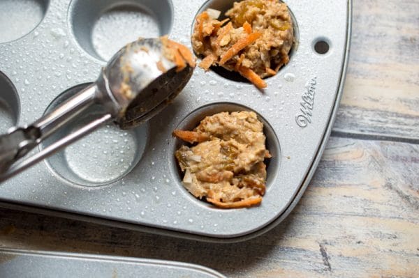 using a cookie scoop to fill muffin tins