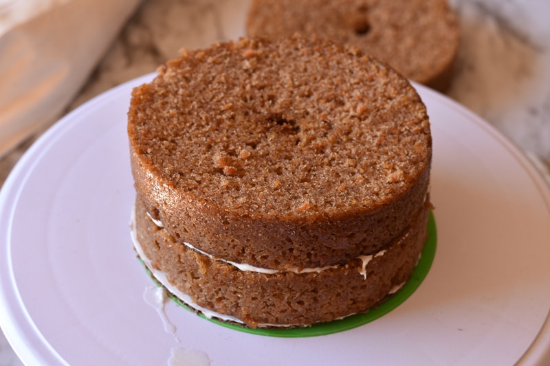 assembling layers of vegan carrot cake