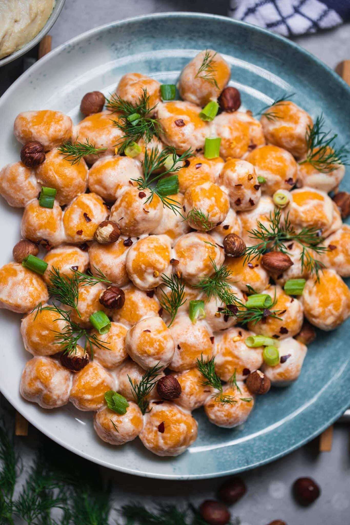 Sweet potato gnocchi on a blue plate with vegan cashew dip