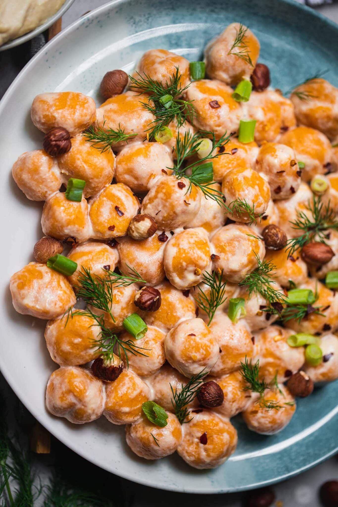 Plate of gluten-free vegan sweet potato gnocchi topped with fresh dill