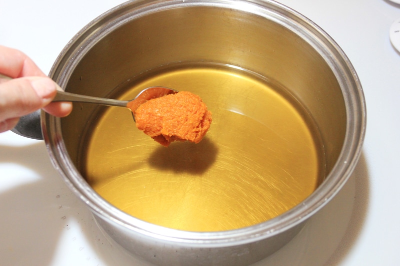 Adding pumpkin puree to brewed coffee in a saucepan