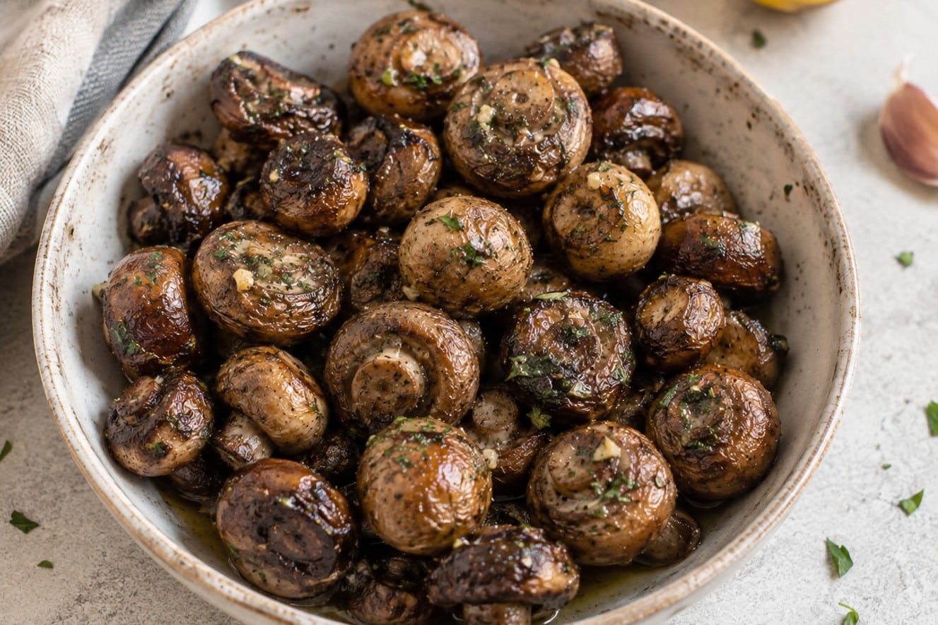 Bowl of broiled lemon-garlic mushrooms garnished with parsley