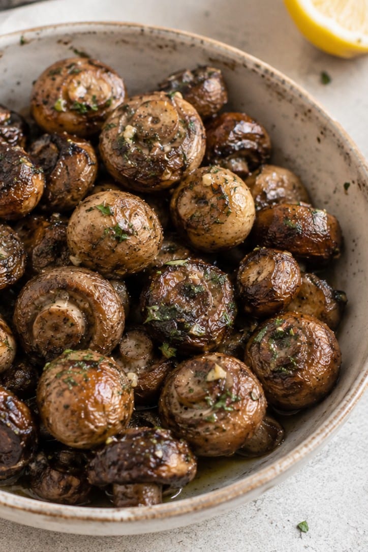Close-up of broiled lemon-garlic mushrooms in a bowl