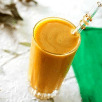 Vegan butternut squash smoothie featured image, overhead close-up of the smoothie in a glass with a glass straw