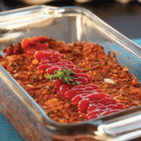 Classic tofu loaf topped with ketchup and fresh parsley in a glass loaf pan