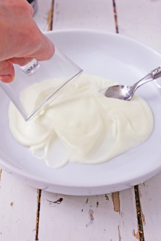 Dipping the rim of a glass mug into melted vegan white chocolate