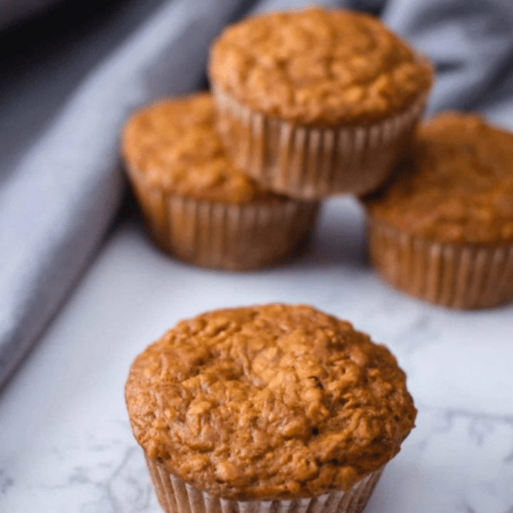 Easy vegan bran muffins stacked on a white marble counter