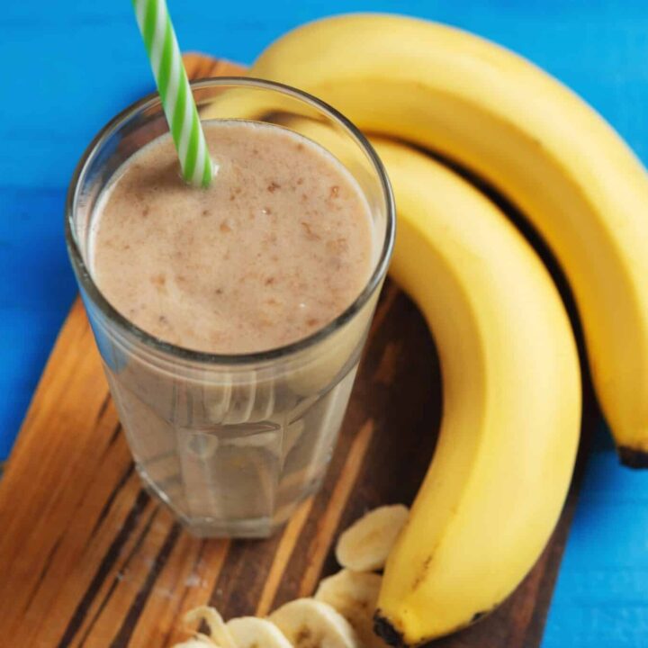 Vegan mocha maca banana smoothie in a glass with bananas