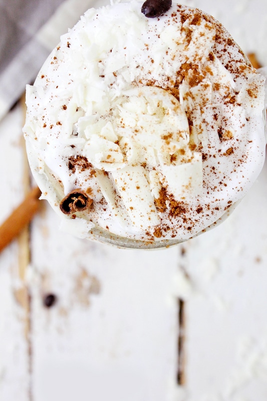 Overhead view of a pumpkin spice latte topped with whipped cream and ground cinnamon