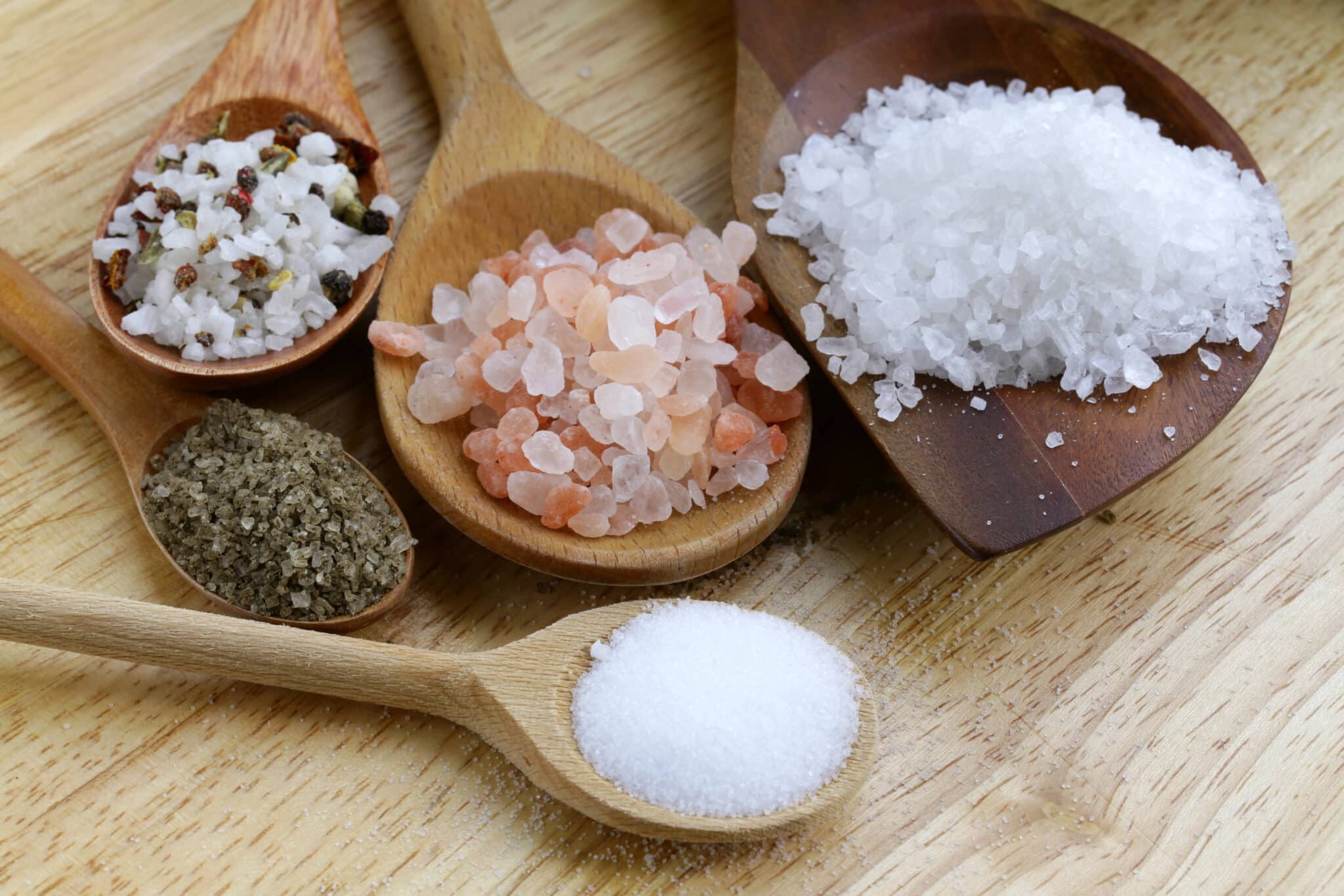 Assortment of salt varieties on wooden spoons