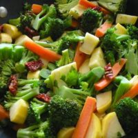 Sautéed broccoli, carrots, and yellow squash with sun-dried tomatoes, square crop