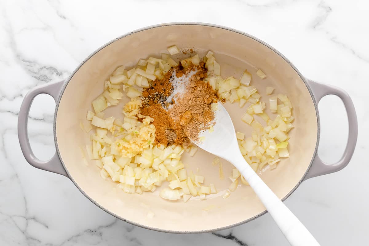 Curry powder, ginger and coriander added to sauteed onion and garlic in a pot